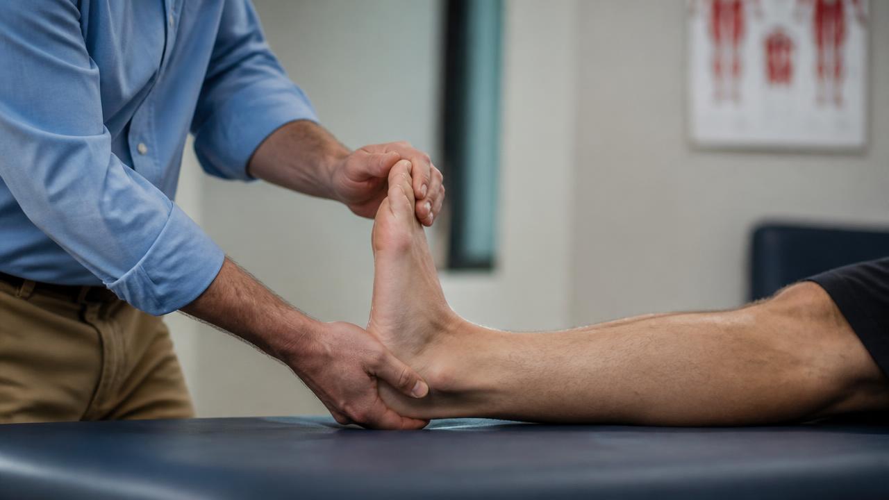 Valutazione clinica della mobilità della caviglia in un paziente adulto durante la visita specialistica