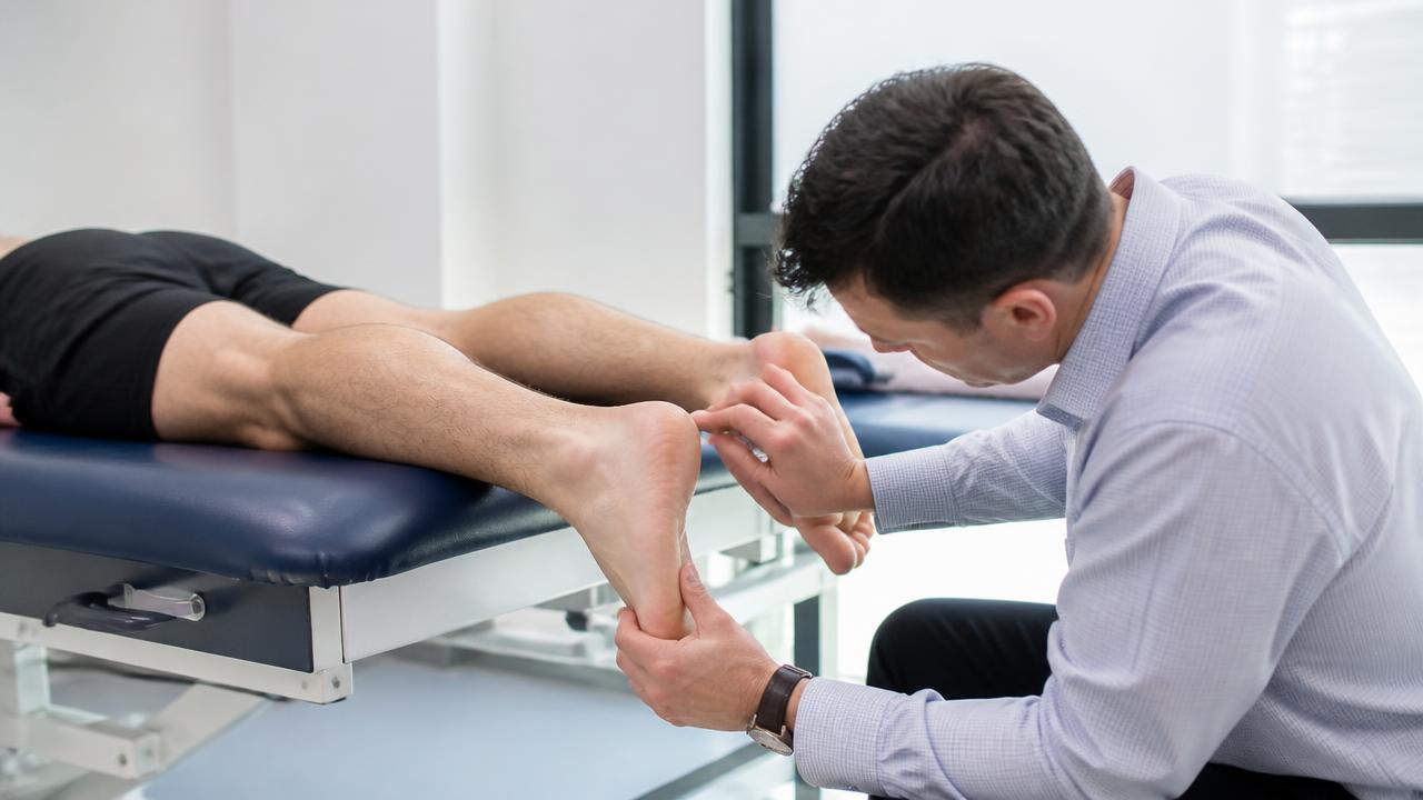 Visita specialistica: palpazione della regione del tendine d'Achille in ambulatorio