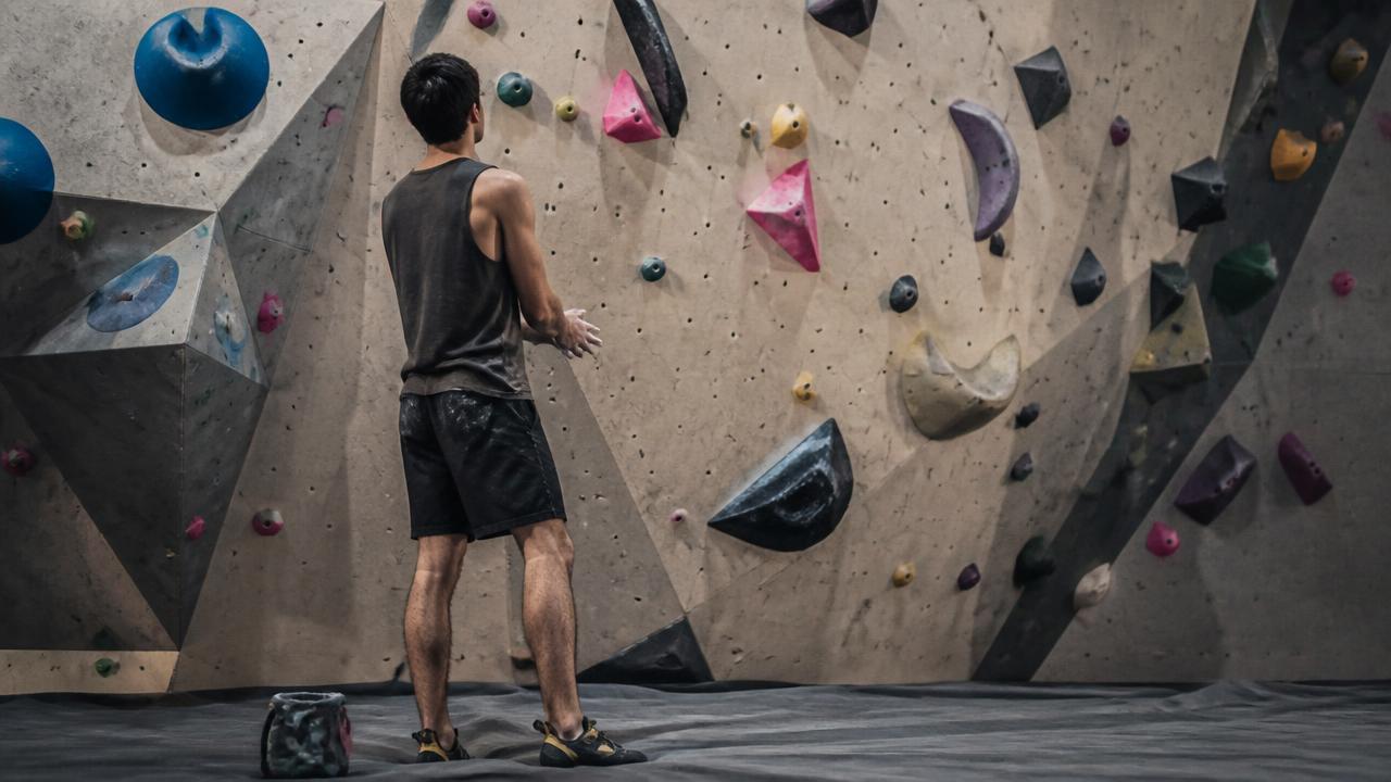 Arrampicatore che torna sulla parete indoor dopo il recupero