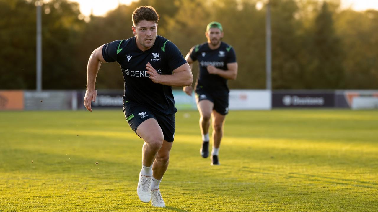 Rugbista che corre durante un allenamento su campo in erba