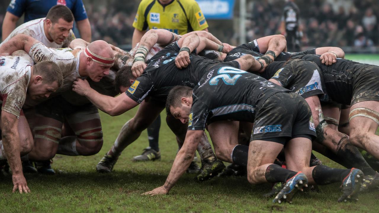 Mischia di rugby con i giocatori in spinta e i piedi in appoggio di punta sul terreno