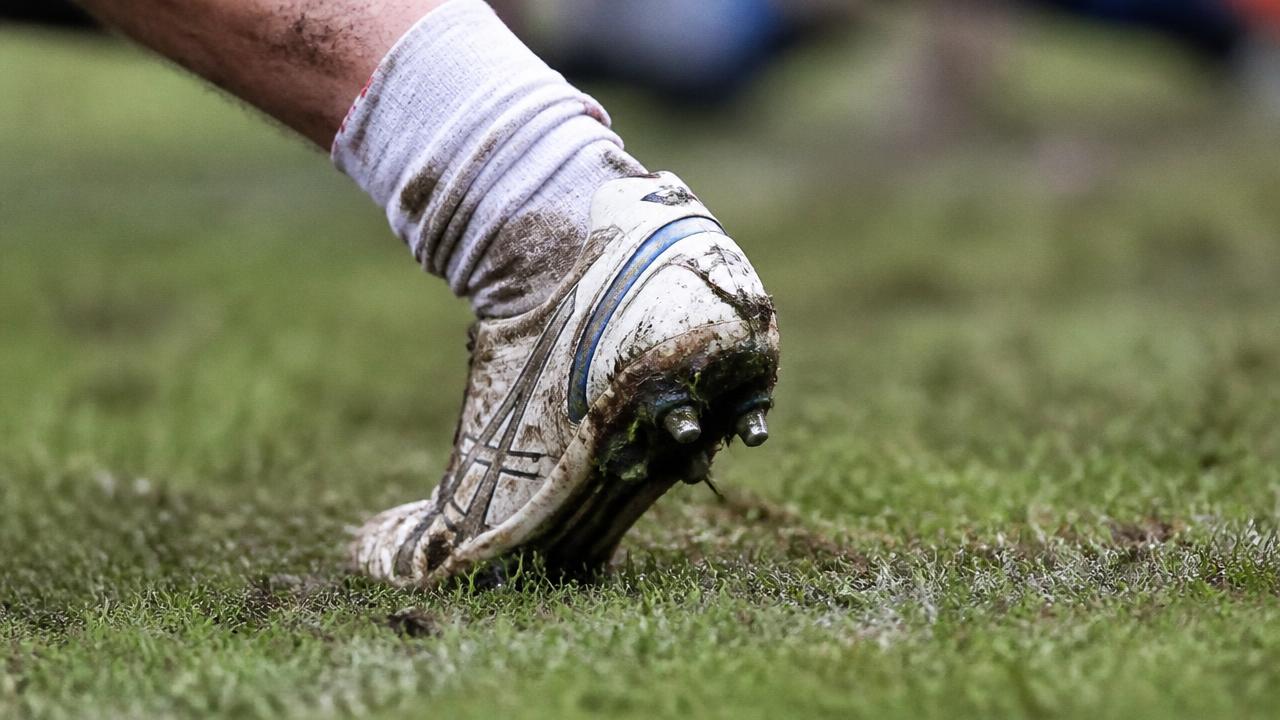 Scarpa da rugby appoggiata sull'erba con l'alluce piegato all'indietro durante la spinta