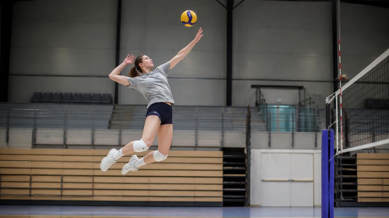 Pallavolista in allenamento durante un salto in attacco in palestra
